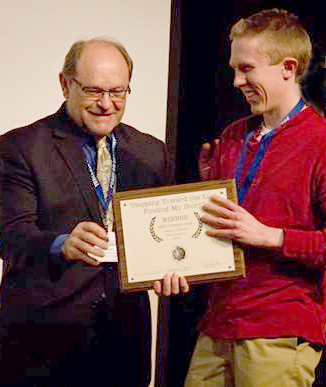 Photo of John Lyden accepting Best Student Film Peace on Earth Film Festival